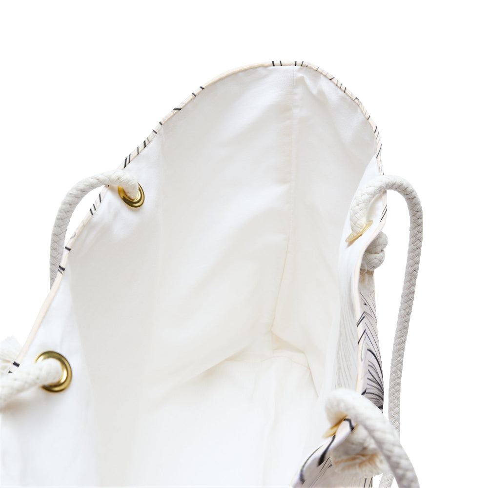 Close-up view of a white tote bag featuring a drawstring closure with white rope threaded through gold-colored metal eyelets—perfect for a stylish and practical everyday carry