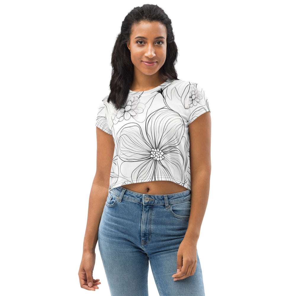 A white all-over print crop tee featuring a detailed floral design, worn by a model with blue jeans—perfect for a stylish and casual outfit