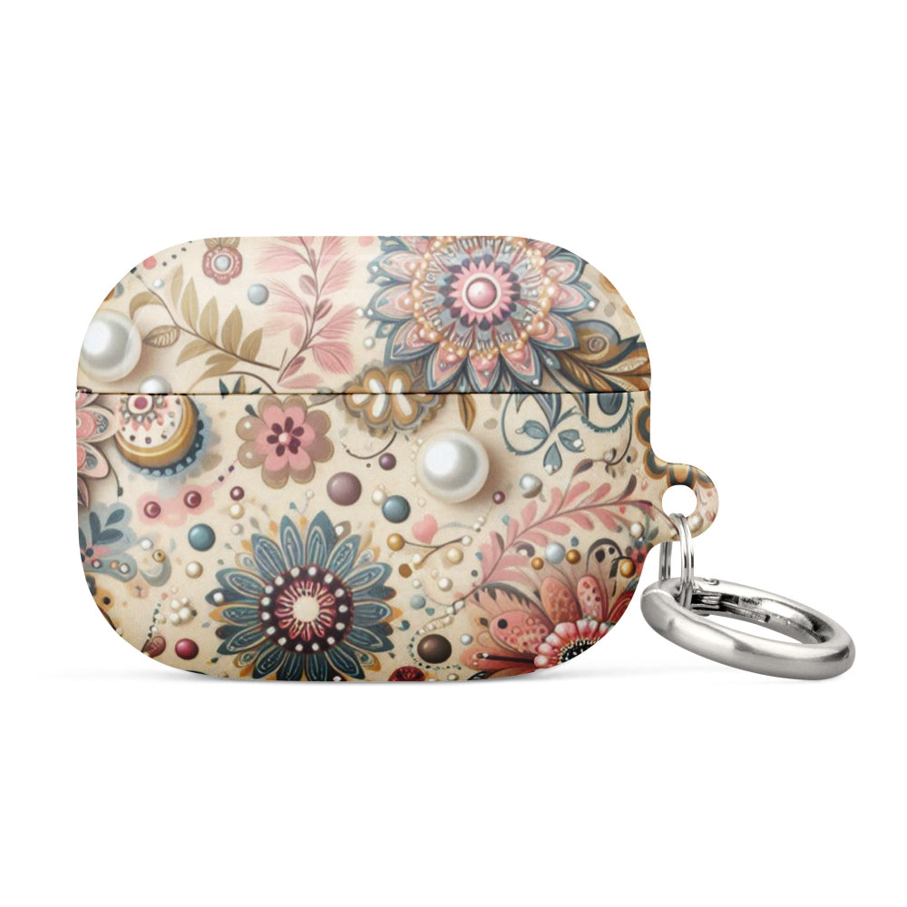 An AirPods case featuring an intricate floral and paisley pattern in shades of pink, blue, and beige, accented by pearl-like details and a metal ring attachment—perfect for a stylish and practical everyday tech accessory